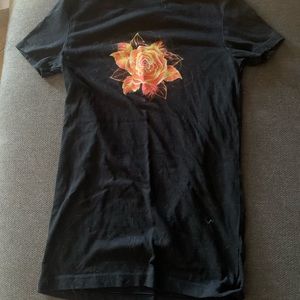 Black, slim fit T-shirt, with a orange flower